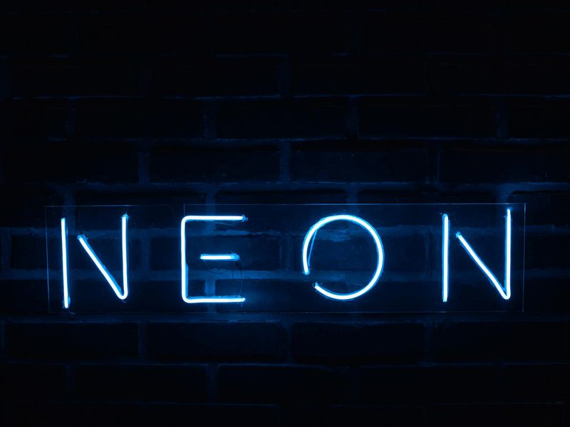 Professional gym atmosphere with neon blue highlights on black walls